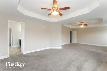 Conyers house for rent - a living room with carpet and a ceiling fan