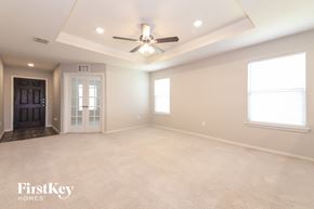 Aubrey house for rent - A spacious room with a ceiling fan and a door on the left.