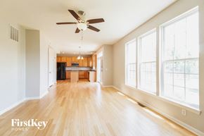 Batavia house for rent - an empty living room with a ceiling fan and a kitchen