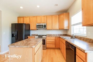 Batavia house for rent - a kitchen with wooden cabinets and granite counter tops