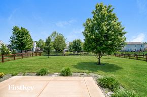 Batavia house for rent - a backyard with a tree and a grass field