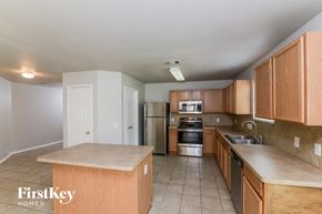 Schertz house for rent - a kitchen with wooden cabinets and stainless steel appliances