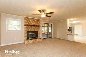 Concord house for rent - a living room with a brick fireplace and a ceiling fan