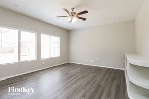 San Tan Valley house for rent - A room with a ceiling fan and wooden flooring.