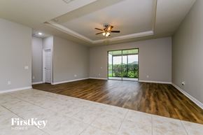 Parrish house for rent - A spacious room with a ceiling fan and a view of greenery outside the window.