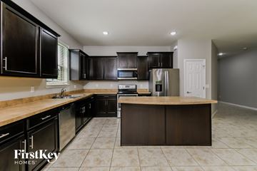 Parrish house for rent - A kitchen with black cabinets and a wooden island.