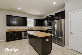 Parrish house for rent - A kitchen with a refrigerator, oven, and sink.