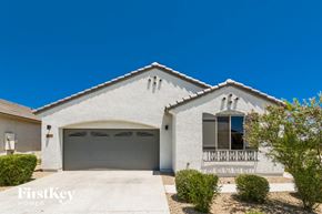Surprise house for rent - a white house with a garage and a blue sky
