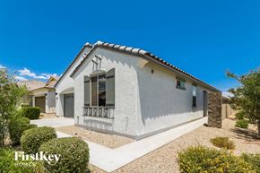 Surprise house for rent - a white house with a porch and a blue sky