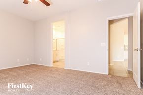 Surprise house for rent - a bedroom with a carpeted floor and a door to a bathroom