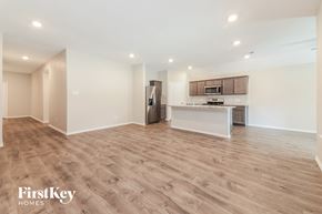 Fate house for rent - A spacious kitchen with wooden flooring and a refrigerator in the corner.