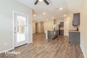 Fate house for rent - A spacious kitchen with wooden floors and a ceiling fan.