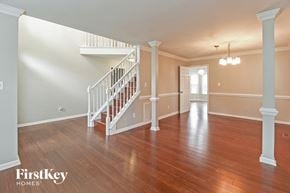 Greensboro house for rent - the foyer and living room of an empty house with wood floors and a staircase