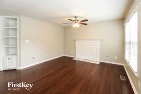 Greensboro house for rent - a living room with wood floors and a ceiling fan