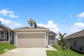San Antonio house for rent - A garage with a brown door is in the middle of a grassy area.