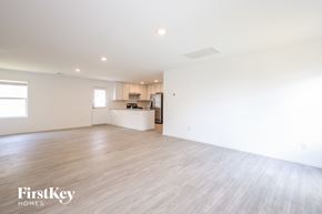 San Antonio house for rent - A spacious, empty room with wooden flooring and white walls.