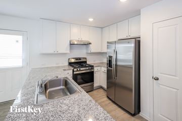 San Antonio house for rent - A kitchen with a stainless steel refrigerator and a granite countertop.