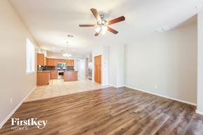 Peoria house for rent - A spacious living room with wooden floors and a ceiling fan.