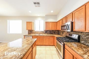 Peoria house for rent - A kitchen with wooden cabinets and granite countertops.