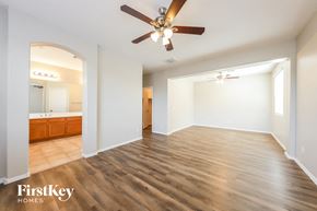 Peoria house for rent - A spacious room with wooden flooring and a ceiling fan.