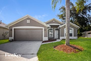 Davenport house for rent - a beige house with a driveway and a palm tree