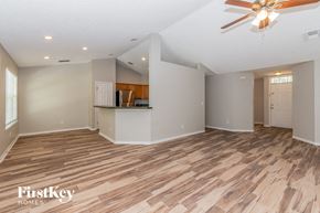 Jacksonville house for rent - A spacious room with wooden flooring and a ceiling fan.