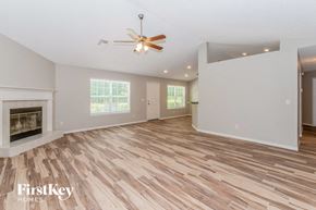 Jacksonville house for rent - A spacious room with a wood floor and a ceiling fan.