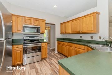 Jacksonville house for rent - A kitchen with wooden cabinets and a green counter top.