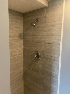Barberton apartment for rent - a large shower with brown tile in a bathroom