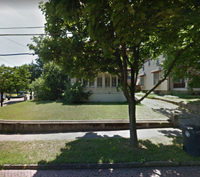 Akron apartment for rent - A tree in a grassy area in front of a white house.