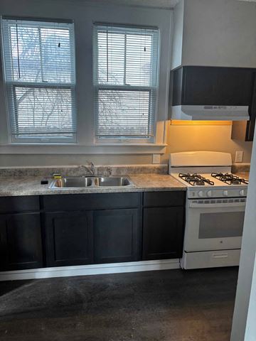 Akron apartment for rent - A kitchen with a stove, sink, and cabinets.