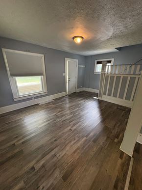 Akron house for rent - A room with wooden floors and a window with blinds.