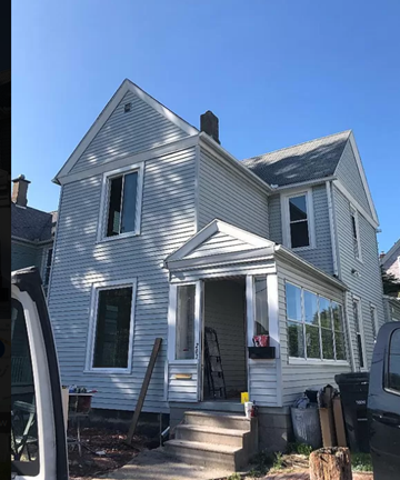 Akron house for rent - A house with a grey exterior and a black truck parked in front.
