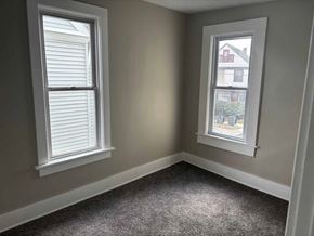 Akron house for rent - A room with two windows, one of which has a view of a building outside.