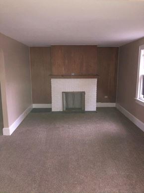 Akron house for rent - an empty living room with a fireplace