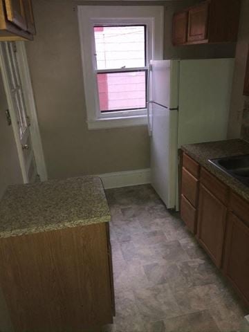 Akron house for rent - a small kitchen with a window and a refrigerator