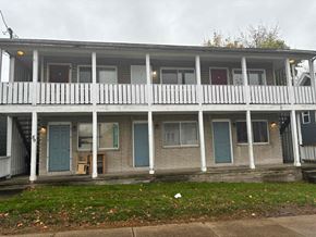 Akron apartment for rent - the front of an apartment building with blue doors and a porch