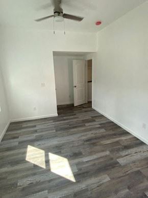 Cleveland house for rent - an empty living room with white walls and a ceiling fan