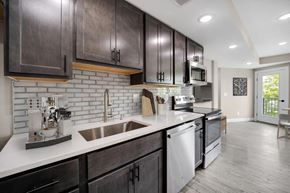 Washington apartment for rent - A kitchen with dark wood cabinets and a white countertop.