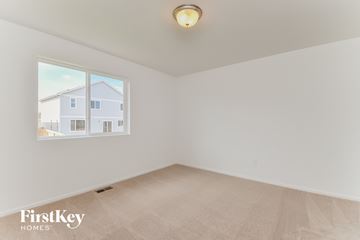 Colorado Springs house for rent - a spacious living room with a large window and beige carpet