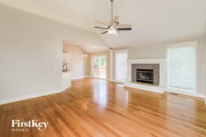 Platte City house for rent - an empty living room with a fireplace and a ceiling fan