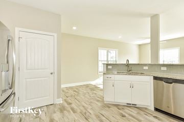 Clarksville house for rent - a kitchen with white cabinets and a sink and a refrigerator