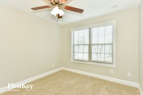 Clarksville house for rent - a bedroom with a ceiling fan and a window