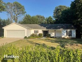 Gainesville house for rent - a house with a lawn in front of it and a garage door