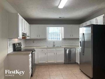 Gainesville house for rent - a kitchen with white cabinets and a stainless steel refrigerator