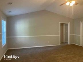 Gainesville house for rent - an empty living room with white walls and a ceiling fan