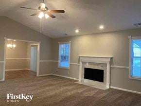 Gainesville house for rent - a living room with a fireplace and a ceiling fan