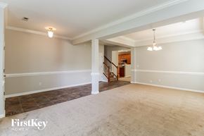 Winston-Salem house for rent - A spacious room with a staircase leading to the upper floor.