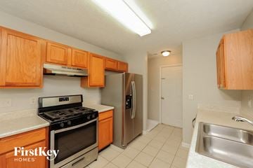 Sugar Hill house for rent - a kitchen with stainless steel appliances and wooden cabinets