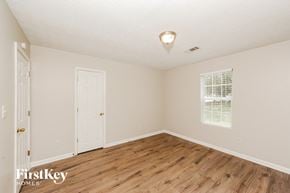 Sugar Hill house for rent - an empty bedroom with a wooden floor and a white door